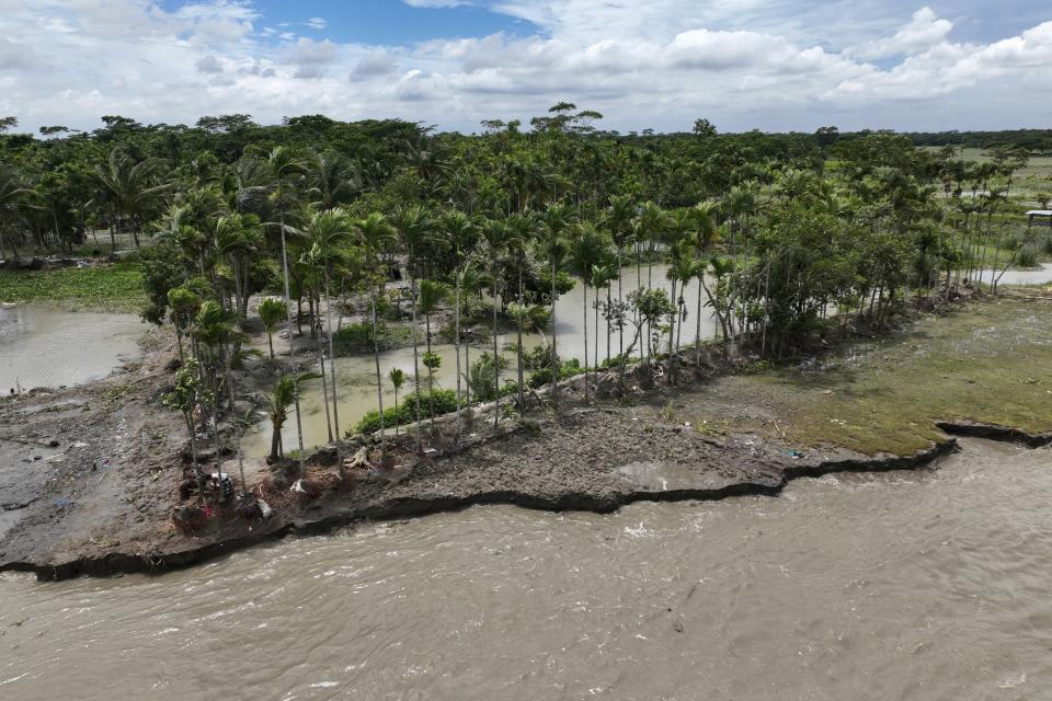 FILE - Erosion caused by the Meghna River is visible in the Ramdaspur village of the Bhola district of Bangladesh on July 5, 2022. Rising seas are eating away at coastlines, storms are battering megacities and drought is exacerbating conflict. (AP Photo/Mahmud Hossain Opu, File)