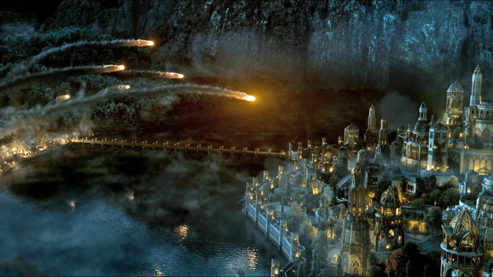A barrage of flaming boulders fly towards the city of Eregion in The Rings of Power season 2