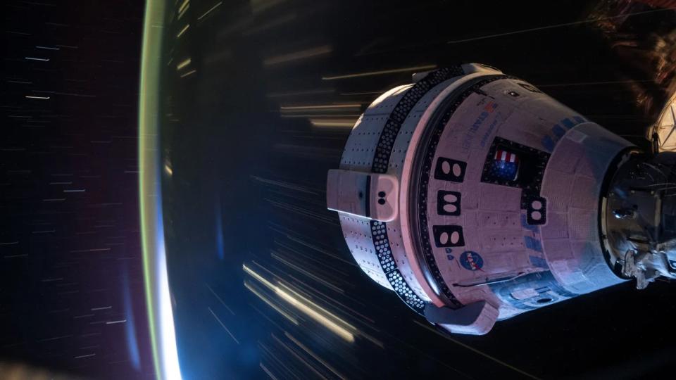     A cone-shaped spacecraft over the earth at night. Light streaks indicate time exposure image and motion. 