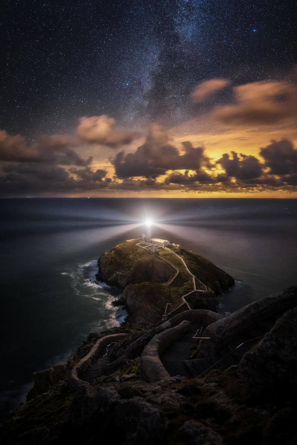 In Anglesey, on the north-western tip of Wales, Alyn Wallace captured a dazzling starry night sky above the bright beam of South Stack lighthouse – with amber clouds standing in contract between the dark sky and water.