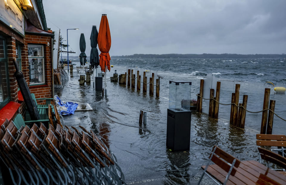 A street in front of the cafes and stores at Tiessenkai in the Kiel district of Holtenau is completely flooded by the Baltic Sea Friday, Oct. 20, 2023. (Axel Heimken/dpa via AP)