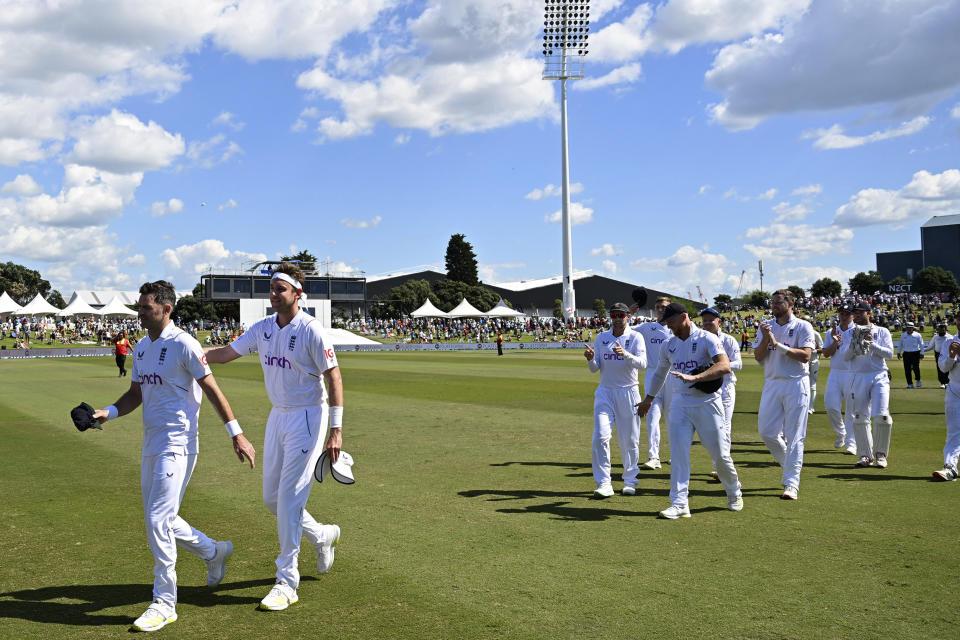 England's James Anderson, left, and Stuart Broad lead the England team from the field after England defeated New Zealand on the fourth day of their cricket test match in Tauranga, New Zealand, Sunday, Feb. 19, 2023. (Andrew Cornaga/Photosport via AP)