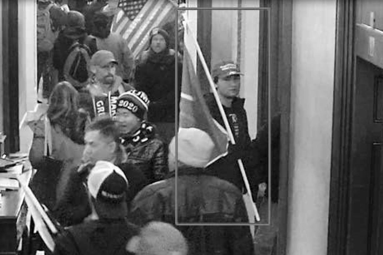 This image from security video of Christian Secor, seen in a hallway in the U.S. Capitol on Jan. 6, 2021, was contained in the Justice Department affidavit and complaint in support of the arrest of Secor. The former UCLA student who stormed the U.S. Capitol while waving a flag promoting a far-right extremist movement has been sentenced to three years and six months in prison for his role in a mob's attack on the building. (Department of Justice via AP)