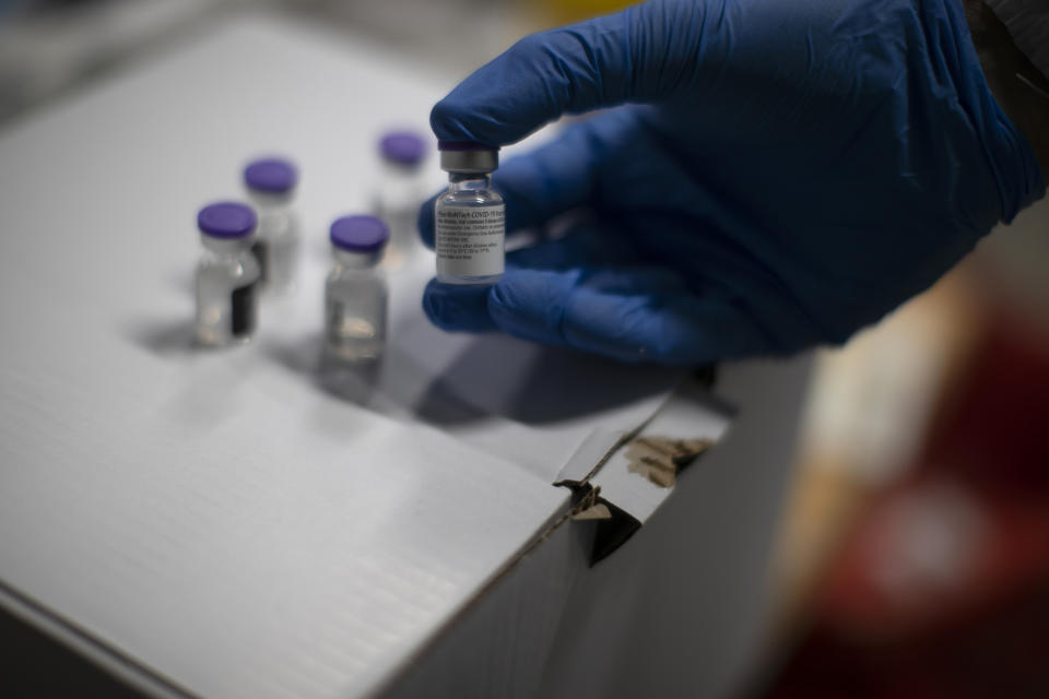 A health worker holds a Pfizer-BioNTech COVID-19 vaccine in Madrid, Spain, Tuesday, Jan. 12, 2021. Spain's rate of infection has shot up to 435 cases per 100,000 residents in the past two weeks, prompting new restrictions as authorities try to bring vaccination up to speed. (AP Photo/Manu Fernandez)