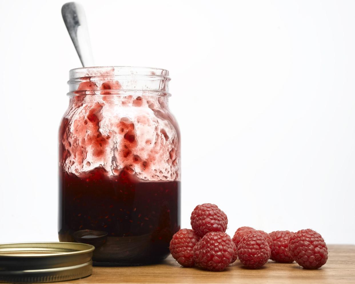 jar os raspberry jam next to raspberries