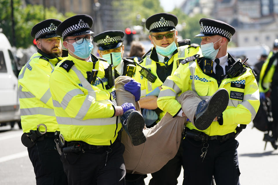 <p>Police carry away a demonstrator during a protest by members of Extinction Rebellion on Whitehall, in central London. Picture date: Tuesday August 24, 2021.</p>
