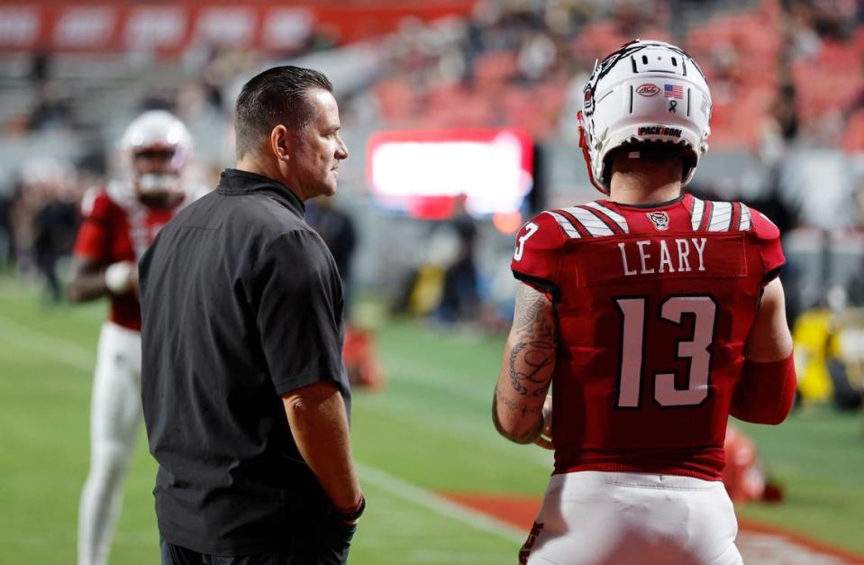 N.C. State offensive coordinator Tim Beck talks with quarterback Devin Leary (13) as he warms up before N.C. State’s game against Florida State at Carter-Finley Stadium in Raleigh, N.C., Saturday, Oct. 8, 2022.