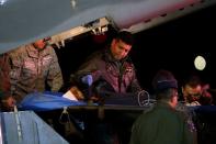 Un niño sobreviviente de un avión Cessna 206 que se estrelló en la espesa selva es transportado en una camilla después de llegar desde San José del Guaviare, a la base aérea militar de CATAM, en Bogotá