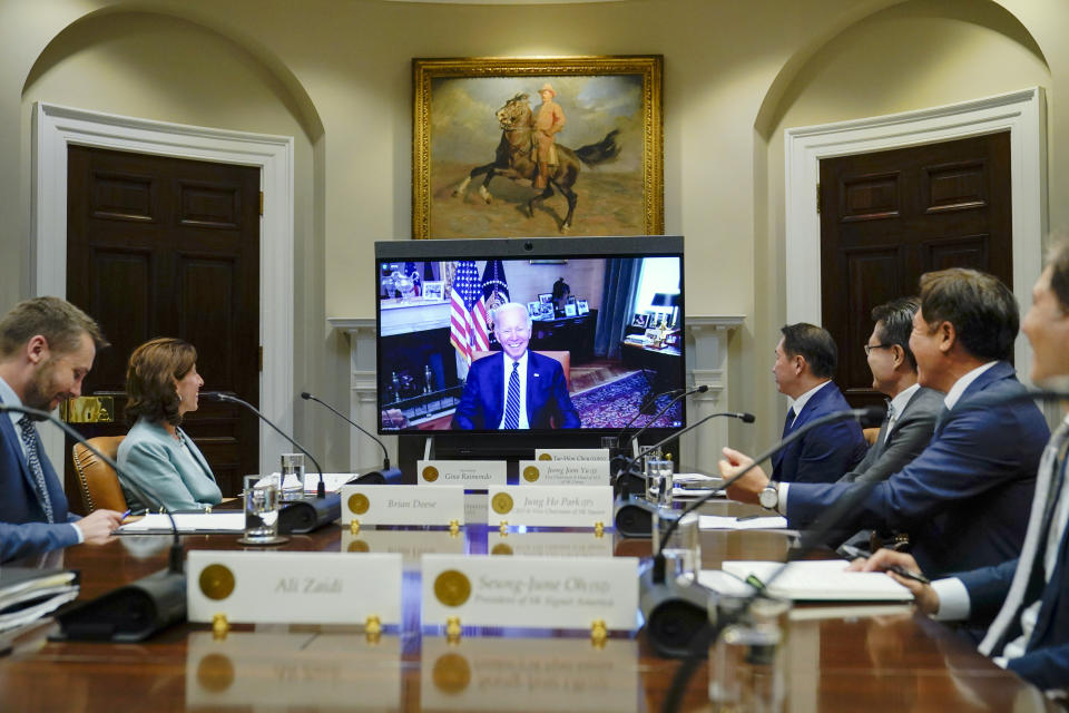 President Joe Biden appears on screen as he meets virtually with SK Group Chairman Chey Tae-won, fourth from right, in the Roosevelt Room of the White House in Washington, Tuesday, July 26, 2022. National Economic Council director Brian Deese, left, Commerce Secretary Gina Raimondo, second form left, Seung-June Oh, President SK Signet America, right, Jung Ho Park, CEO and Vice Chairman of SK Square, second from right, and Jeong Joon, Vice Chairman and CEO, third from right, listen. (AP Photo/Susan Walsh)