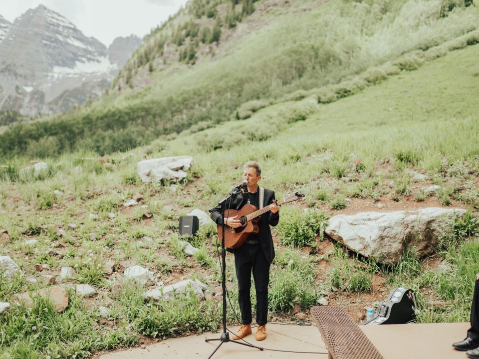 musician playing the guitar at abi's wedding in maroon bells amphitheater