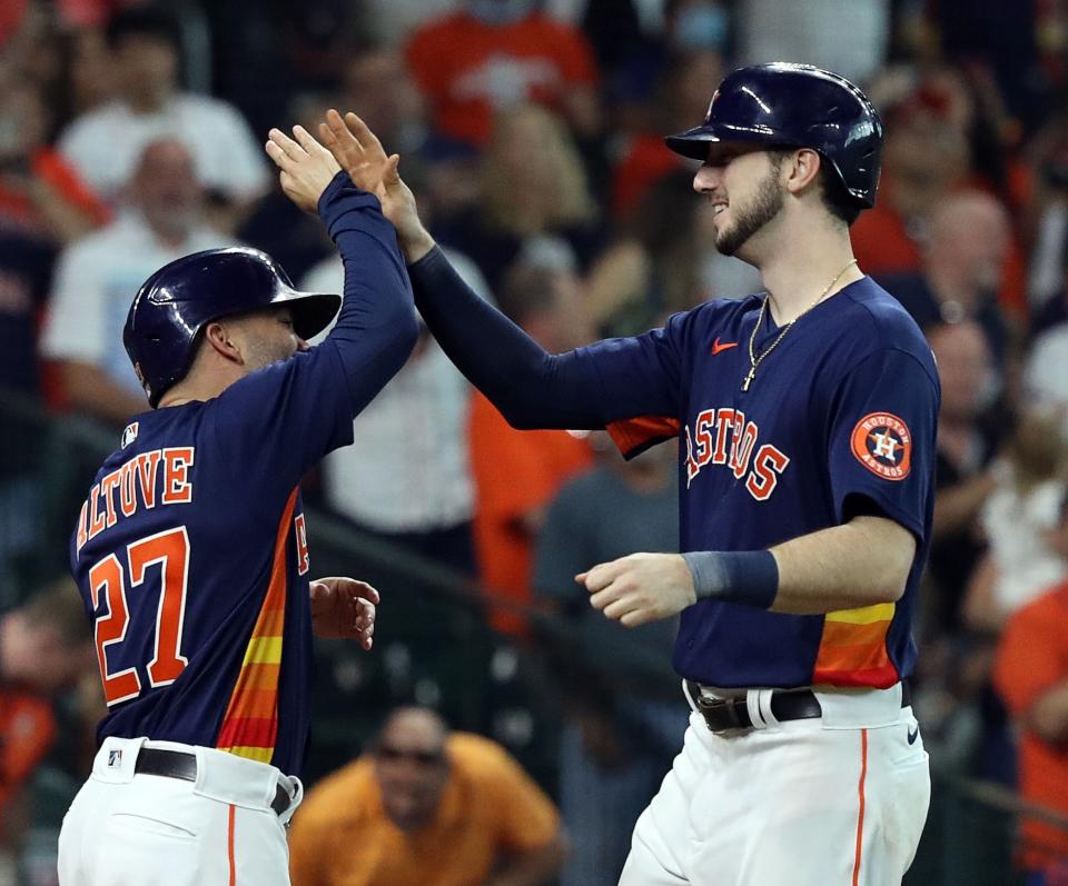 HOUSTON, TEXAS - OCTOBER 03: Kyle Tucker #30 of the Houston Astros receives a high five from Jose Altuve #27 after hitting a two run home run in the sixth inning against the Oakland Athletics at Minute Maid Park on October 03, 2021 in Houston, Texas. (Photo by Bob Levey/Getty Images)