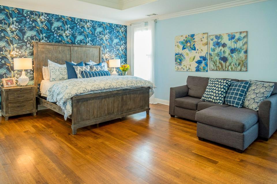 The primary bedroom is large and uses a palette of soft shades of blue to set a relaxing mood.