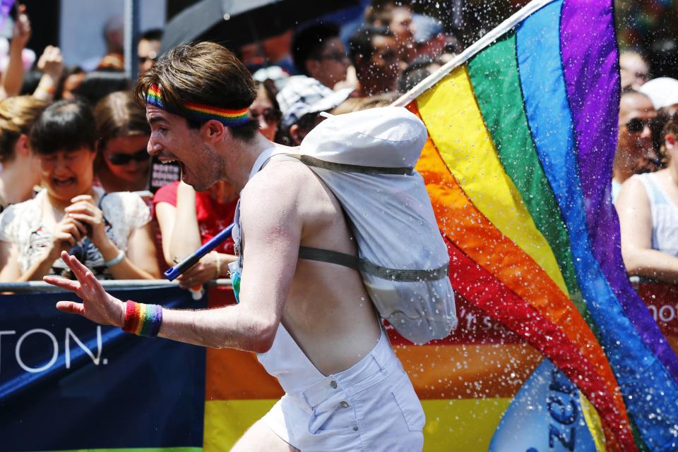 A man runs from water being sprayed at him during the "WorldPride" gay pride Parade in Toronto