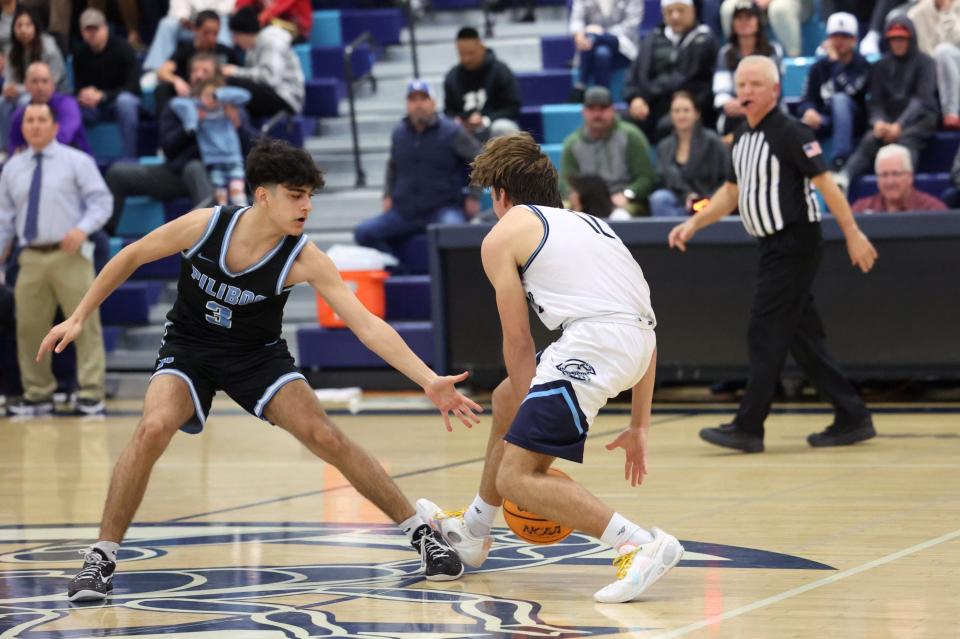Camarillo's Tyler Hook dribbles between his legs while being guarded by a Pilibos player during the Scorpions' 63-33 win in a Division 3AA second-round game at Camarillo High on Friday, Feb. 9, 2024. Hook finished with 14 points.