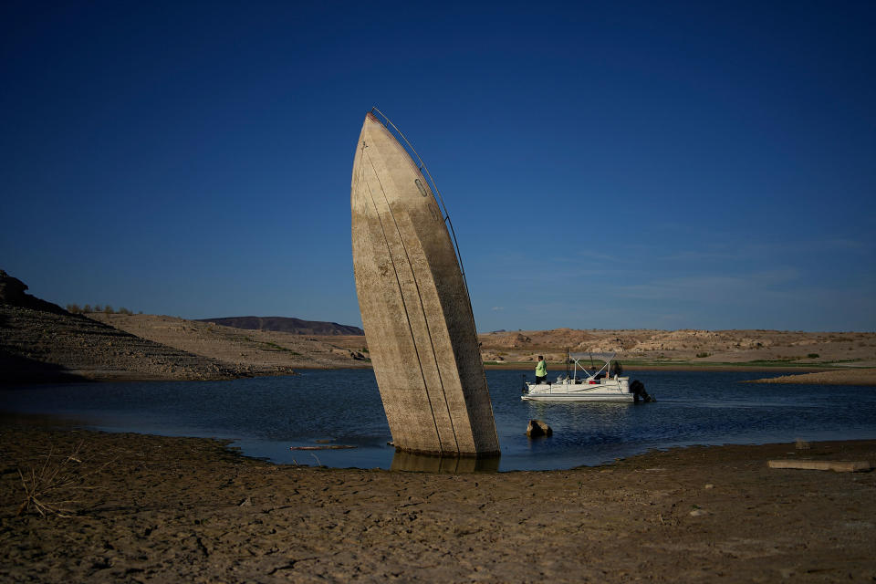 A formerly sunken boat sits upright into the air with its stern stuck in the mud along the shoreline of Lake Mead at the Lake Mead National Recreation Area, near Boulder City, Nev. on June 10, 2022.<span class="copyright">John Locher—AP</span>