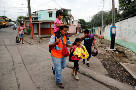 Displaced people walk along a road from an area affected by the eruption of Fuego volcano in Escuintla, Guatemala June 5, 2018. REUTERS/Luis Echeverria