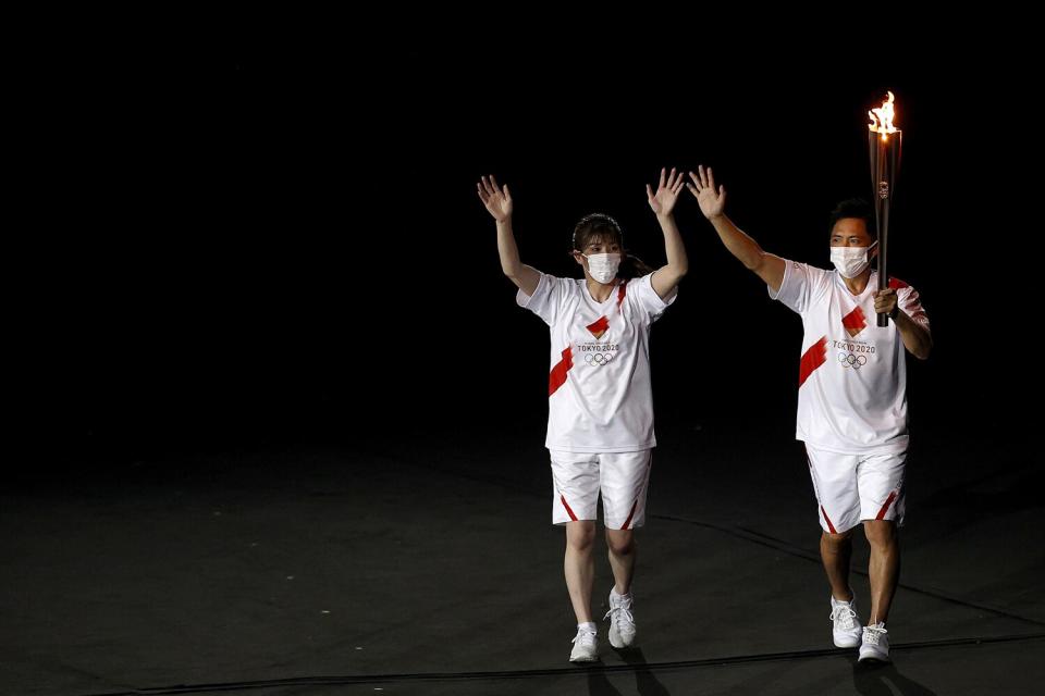 The torch carriers enter the stadium with the Olympic torch during the Opening Ceremony