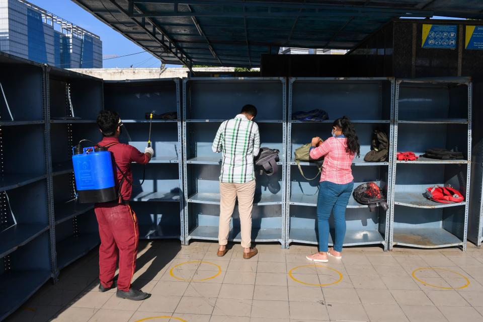 A worker sanitises bags as students arrive at an examination centre for Joint Entrance Examination (JEE ) Main-2020, one of the most competitive entrance exams for entry to top national engineering colleges, in Noida on September 1, 2020. (Photo by Prakash SINGH / AFP) (Photo by PRAKASH SINGH/AFP via Getty Images)