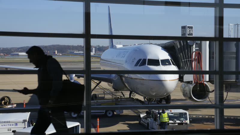 A United Airlines plane sits at a gate at Ronald Reagan Washington National Airport in Arlington, Va., Nov. 23, 2022. United Airlines says that it will start boarding passengers in economy class with window seats first starting next week, a move that will speed up boarding times for flights. 