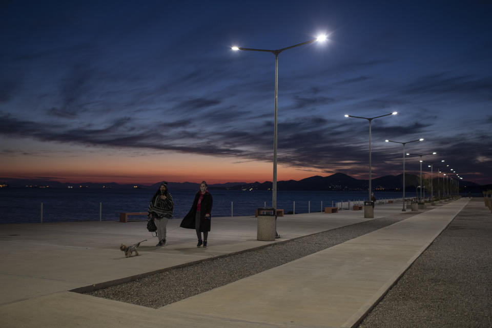 People walk by the seain Drapetsona suburb of Piraeus, near Athens, on Monday. A second nationwide lockdown is in place until the end of November, but the restrictions are widely expected to be extended into December in some form. (Photo: ASSOCIATED PRESS)