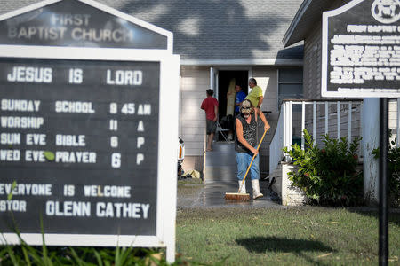 Residents clean up after Hurricane Irma heavily damaged the First Baptist Church in Everglades City, Florida, U.S., September 11, 2017. REUTERS/Bryan Woolston