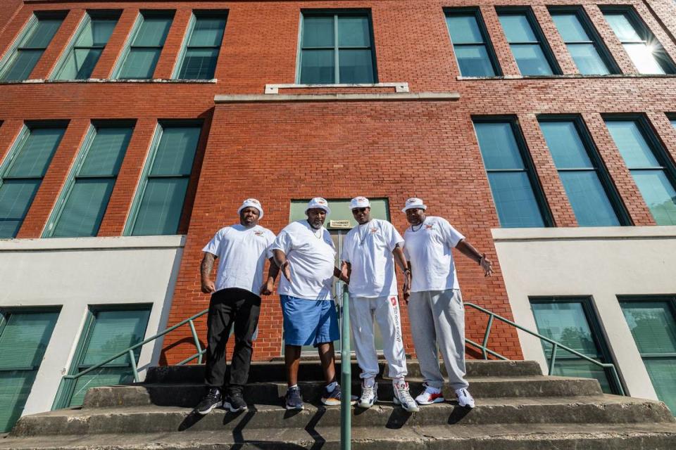 Former Butler Place residents, from left, Tremayne Kilgore, LC Timms, Joe Collier and Greg Wilson are photographed in front of their old elementary school, Carver-Hamilton Elementary, adjacent to Butler Place.