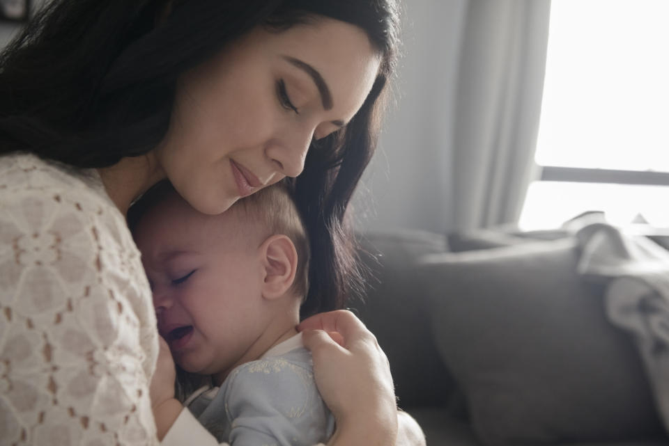 A woman comforting a crying baby