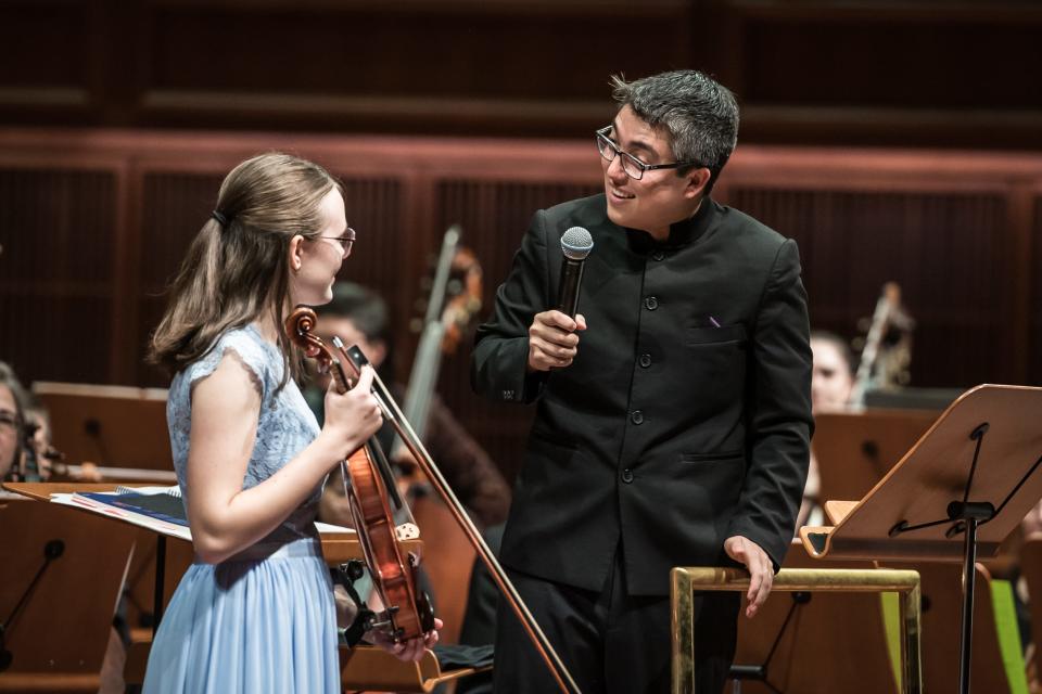 Milwaukee Symphony assistant conductor Ryan Tani chats with violinist Jane Story during a concert for school groups Oct. 26, 2023 at the Bradley Symphony Center.