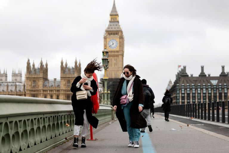 La gente lucha contra el viento mientras camina por el puente de Westminster en el centro de Londres, el 18 de febrero de 2022, mientras la tormenta Eunice desató fuertes vientos por todo el país.