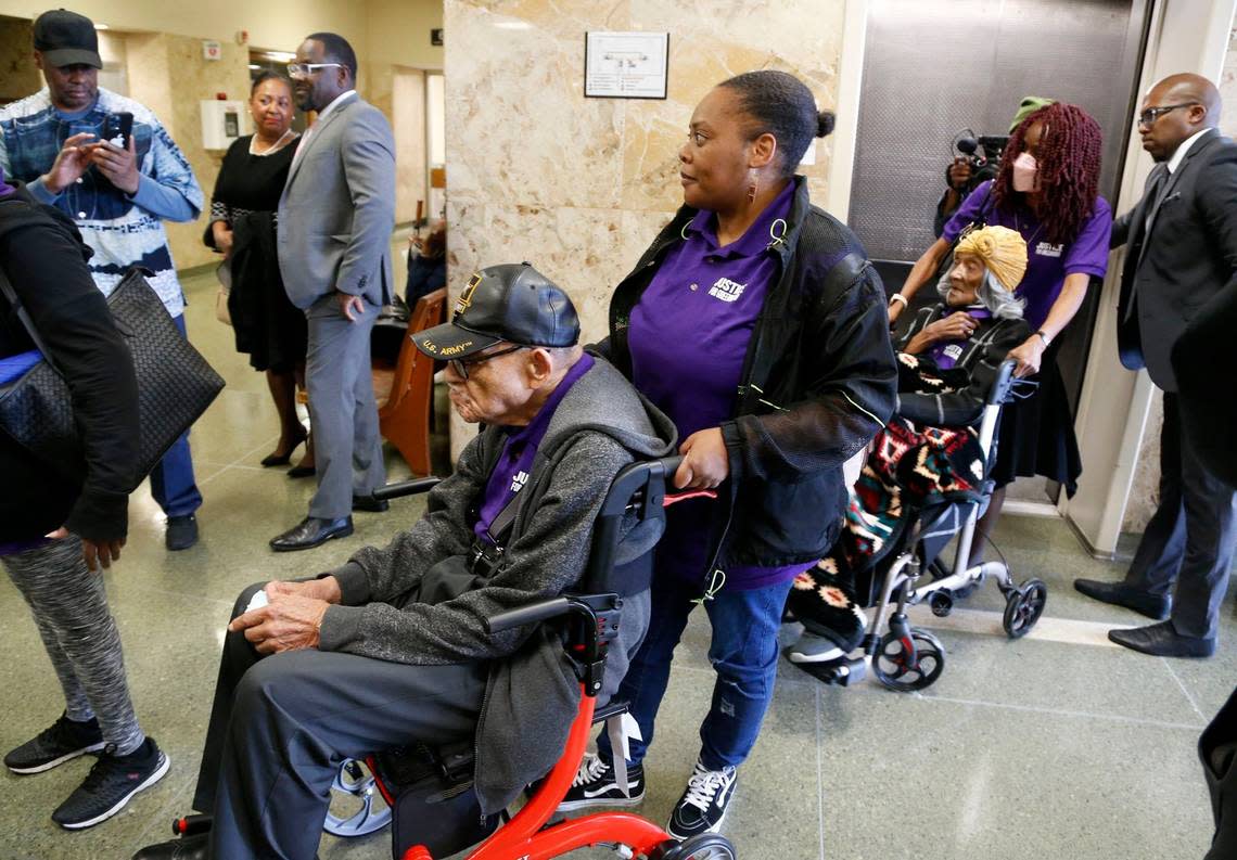 Hughes Van Ellis, 101, foreground left, and Lessie Benningfield Randle, 107, right, survivors of the 1921 Tulsa Race Massacre, are wheeled outside a courtroom at the Tulsa County Courthouse, Monday, May 2, 2022, in Tulsa, Okla. A judge ruled Monday that a lawsuit can proceed that seeks reparations for survivors and descendants of victims of the massacre. (Stephen Pingry/Tulsa World via AP)