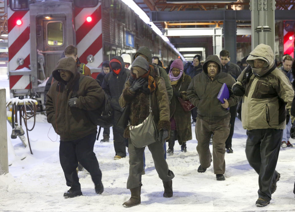 Commuters arrive at the La Salle Street commuter rail station as they experience temperatures well below zero and wind chills expected to reach 40 to 50 below, Monday, Jan. 6, 2014, in Chicago. (AP Photo/Charles Rex Arbogast)