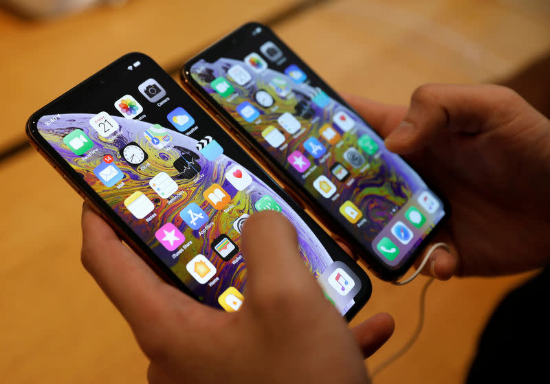 FILE PHOTO: A customer compares the size of the new iPhone XS and iPhone XS Max at the Apple Store in Singapore September 21, 2018. REUTERS/Edgar Su/File Photo