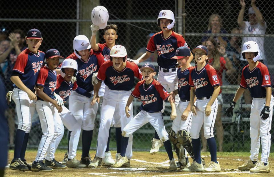 M-O-T players gather at home to celebrate a two-run homer by Nate Collins to open the scoring in the first inning of M-O-T's 10-2 win against Naamans in the state Little League majors division championship at Nanticoke Little League in Seaford, Delaware, Saturday, July 29, 2023. M-O-T will represent Delaware in regional play beginning August 6 in Bristol, Conn.