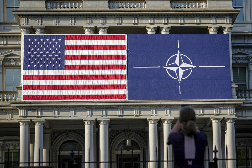 09 July 2024, USA, Washington: A passer-by takes an early morning photo of the fa'ade of the Eisenhower Building with the US and NATO flags. The NATO summit begins with the celebrations to mark the 75th anniversary of the defense alliance. Photo by: Kay Nietfeld/picture-alliance/dpa/AP Images