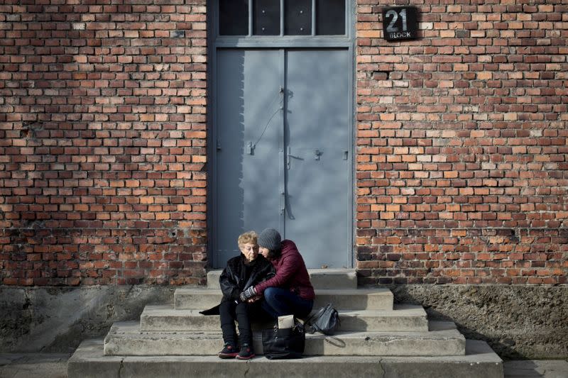 Jona Laks, survivor of Dr. Josef Mengele's twins experiments, and her granddaughter, Lee Aldar sit on the stairs as they visit the Auschwitz death camp in Oswiecim