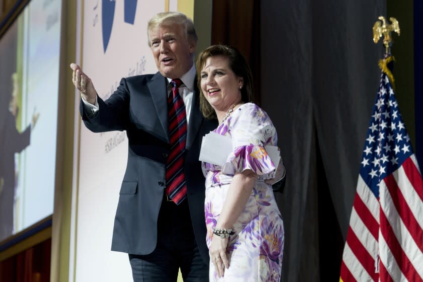 FILE - In this May 22, 2018 file photo, Susan B. Anthony List President Marjorie Dannenfelser, right, stands on state with President Donald Trump at the Susan B. Anthony List 11th Annual Campaign for Life Gala at the National Building Museum in Washington. Even as many religious organizations, from liberal to conservative, denounced the Trump administration's policy of separating immigrant families at the U.S.-Mexico border, some major advocacy groups that depict themselves as 