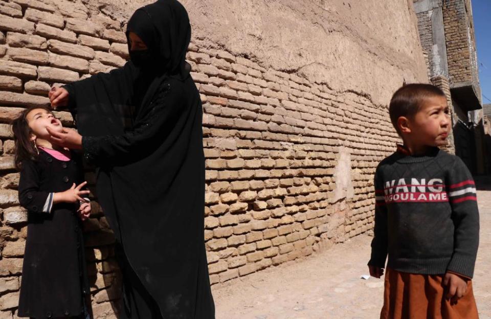 A polio worker administers the vaccine to Afghan children in Herat, Afghanistan, 31 March