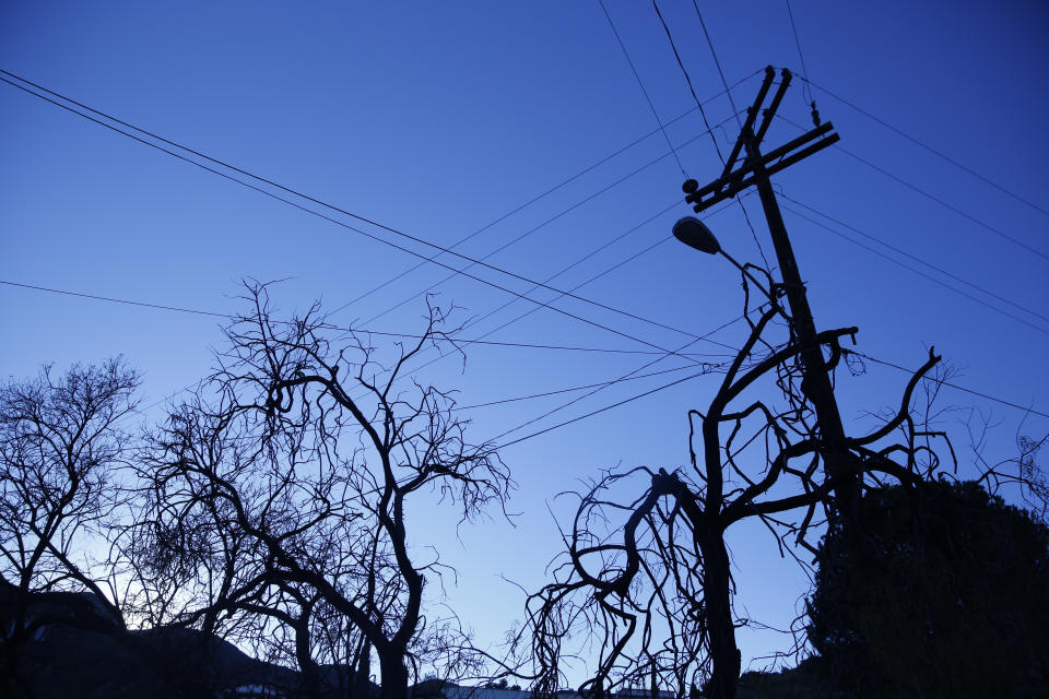 FILE - Tree branches and utility cables are silhouetted as the sun rises over the town of Bisbee, Ariz., Oct. 26, 2021. An Arizona judge has ruled that the Church of Jesus Christ of Latter-day Saints may not use the state's “clergy-penitent privilege” to refuse to answer questions or turn over documents in a child sex-abuse case. (AP Photo/Dario Lopez-Mills, File)