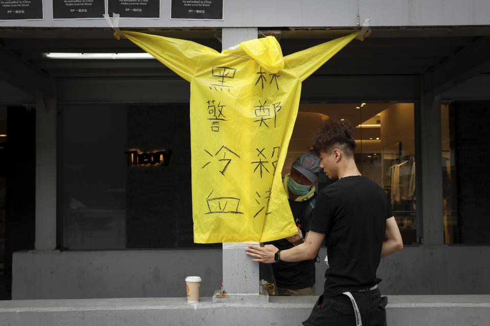 Protesters place a raincoat bearing the words "Cold blooded black police, Carrie Lam kill Hong Kong" on the site where a man fell to his death a day earlier after hanging a protest banner on the scaffolding of a shopping mall in Hong Kong, Sunday, June 16, 2019. Hong Kong was bracing Sunday for another massive protest over an unpopular extradition bill that has highlighted the territory's apprehension about relations with mainland China, a week after the crisis brought as many as 1 million into the streets. (AP Photo/Vincent Yu)