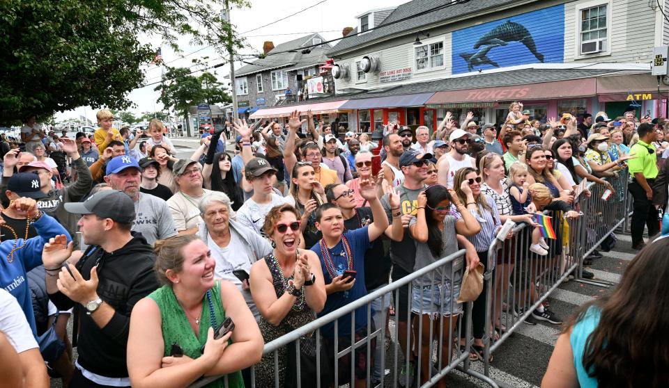 Participants stand many deep along Commercial Street in Provincetown as the Carnival parade passes with revelers tossing beads.