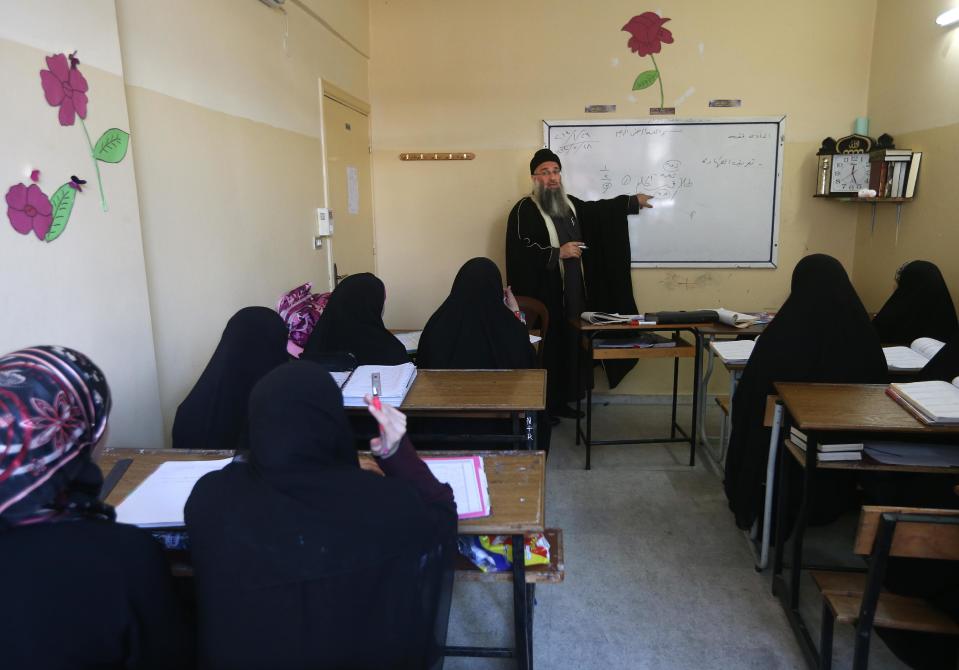 In this picture taken on Wednesday Jan. 29, 2014, Lebanese Sunni cleric Sheik Raed Hlayhel, center background, gives a lesson on Islamic jurisprudence for women at al-Amin institute, in the northern city of Tripoli, Lebanon. From radical preachers to irreverent taxi drivers, anger is spreading through Lebanon’s Sunni community toward the country’s military, adding a dangerous twist to Lebanon’s instability, already shaken by relentless bombings. Many Sunnis accuse the military of siding with their rivals, the powerful Shiite group Hezbollah, as sectarian tensions grow in Lebanon, stoked by the civil war in neighboring Syria. (AP Photo/Hussein Malla)