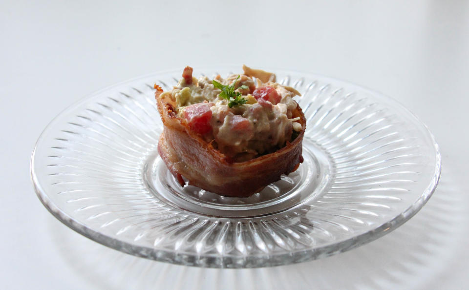 Cups made of bacon are something I never knew I needed. Since you can&rsquo;t have bread on keto, finding a vessel for a BLT becomes a fun challenge. This BLT comes in the form of a chicken salad, using chicken as an added protein. The mayonnaise and avocado make&nbsp;the chicken salad creamy and adds delicious fat. This recipe is great for making ahead to ensure lunch success or as a new cookout addition. Serves 8. <br /><br /><strong>Chicken Salad</strong>:<br />2 lb chicken breasts, cooked and shredded<br />2 avocados, halved and sliced<br />3 tomatoes, diced<br />2 green onion, diced<br />1 cup mayonnaise (Duke&rsquo;s, if you know what&rsquo;s up)<br />Salt and pepper, to taste<br />4 slices bacon <br />2 cups arugula<br /><br /><strong>Bacon Cups</strong>:<br />16 slices bacon <br /><br />For Bacon Cups: Take 8 slices of bacon and cut crosswise. Invert a muffin tin and lay two halved strips on both sides. Wrap entire cup with a whole slice of bacon. Repeat for each cup. Heat oven to 400 degrees F. Place inverted muffin tin on wider baking pan for easier cleanup. Bake until crispy, 20-25 minutes. <br /><br />For Chicken Salad: Dice bacon and saute in a&nbsp;skillet over medium heat until crispy, 6-8 minutes. Move to towel-lined plate to cool. Combine chicken, avocado, tomatoes, green onion, mayonnaise and bacon. Season with salt and pepper. Line bottom of bacon cups with bed of arugula and top with chicken salad.