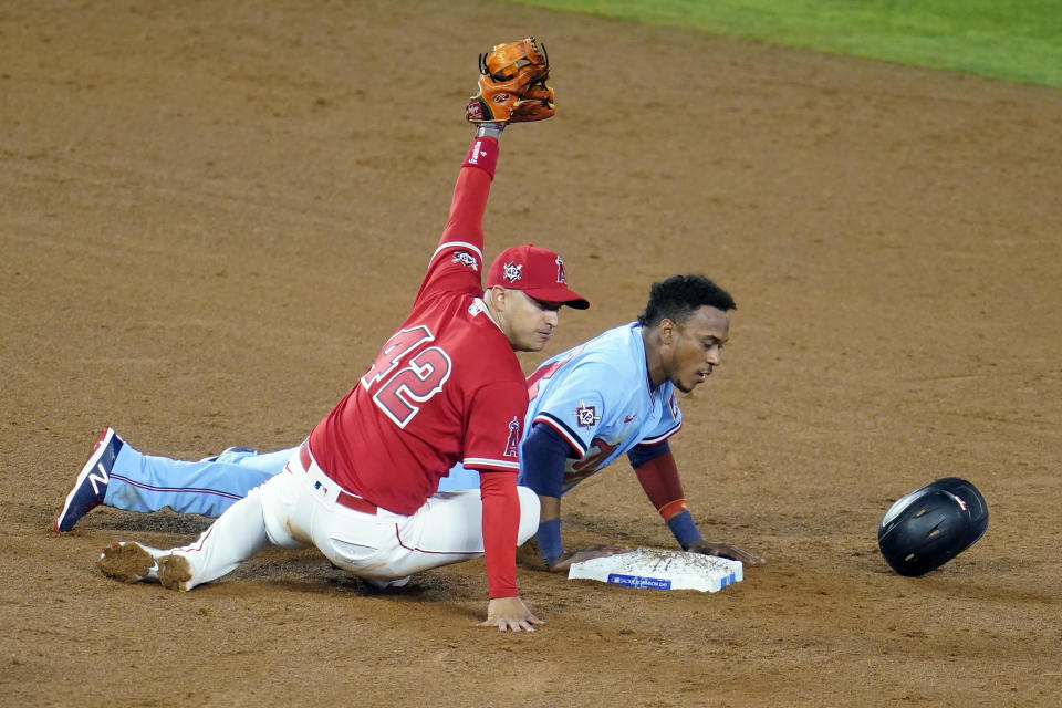 Minnesota Twins' Jorge Polanco, right, is safe at second base next to Los Angeles Angels second baseman David Fletcher on a pick-off attempt during the sixth inning of a baseball game Friday, April 16, 2021, in Anaheim, Calif. (AP Photo/Marcio Jose Sanchez)