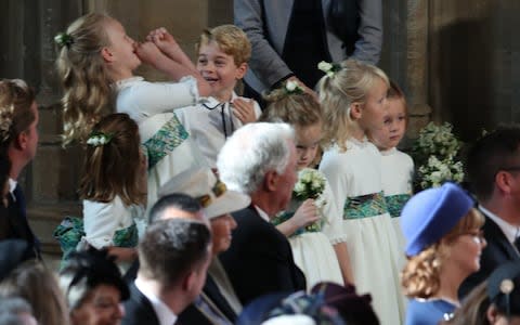 Prince George is pictured playing with one of the bridesmaids as they wait for the ceremony to begin - Credit: PA