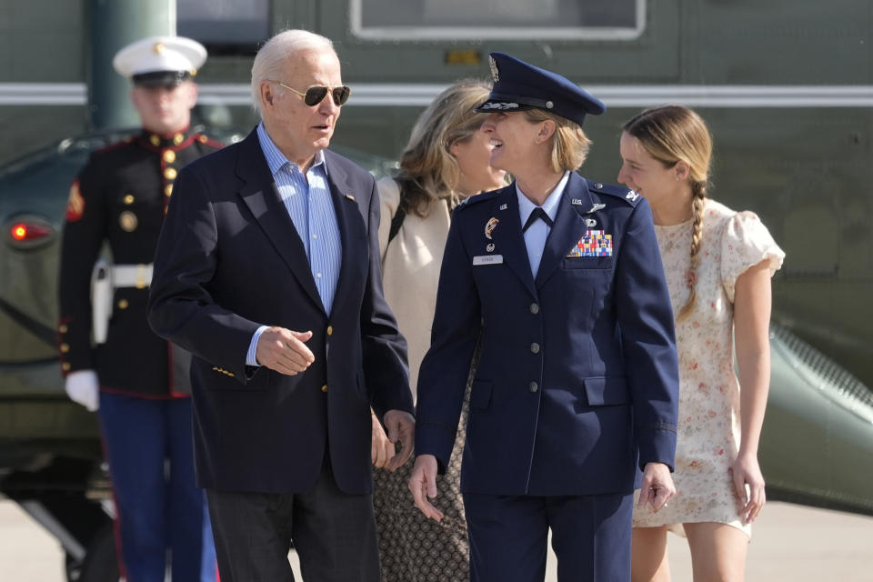 President Joe Biden is escorted by Air Force Col. Angela Ochoa, Commander, 89th Airlift Wing, as he arrives at Andrews Air Force Base, Md., Wednesday, June 12, 2024. Biden is headed to Italy for the G7 summit. Biden's granddaughter, Finnegan Biden, walks right. (AP Photo/Alex Brandon)