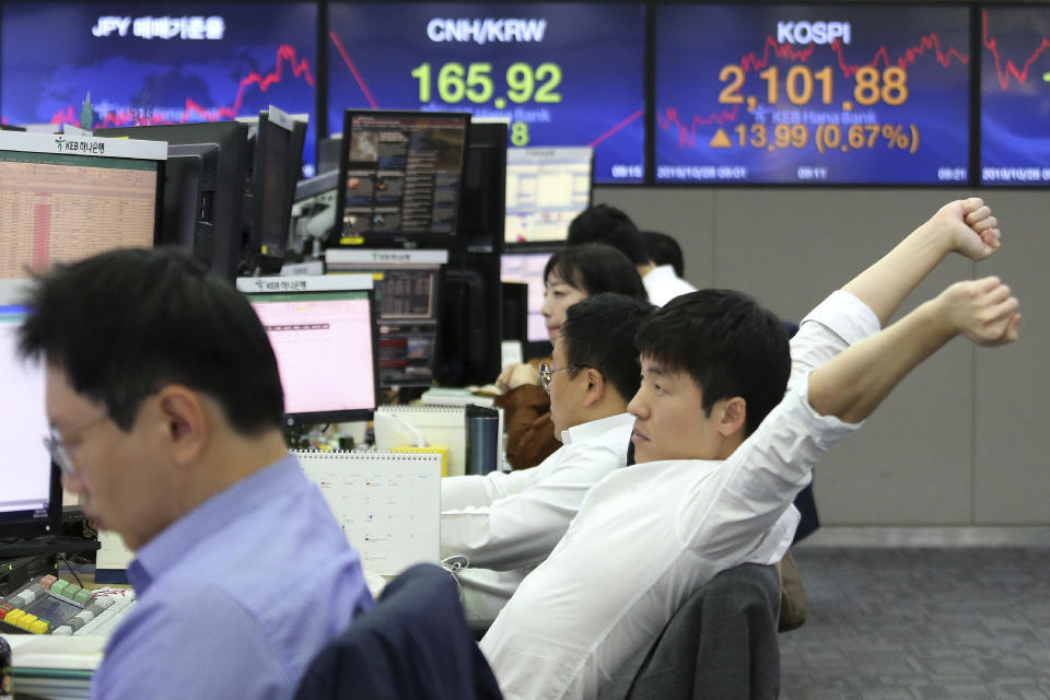 A currency trader stretches at the foreign exchange dealing room of the KEB Hana Bank headquarters in Seoul, South Korea, Monday, Oct. 28, 2019. (AP Photo/Ahn Young-joon)