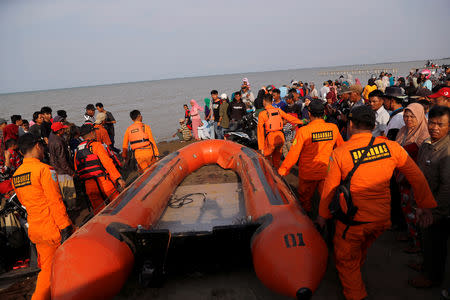 Rescue team members carry the boat heading to the Lion Air, flight JT610, sea crash site off the coast of Karawang regency, West Java province, Indonesia, October 29, 2018. REUTERS/Beawiharta