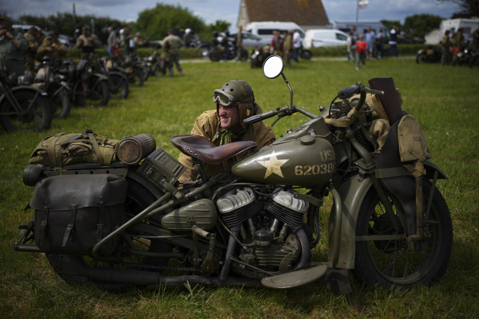 Un actor realiza algunos trabajos de mantenimiento en su motocicleta Harley Davidson vintage del ejército de los Estados Unidos en la playa de Utah cerca de Sainte-Marie-du-Mont, Normandía, Francia, el martes 4 de junio de 2024. Un total de 150 motocicletas Harley Davidson vintage del ejército de los Estados Unidos participaron el martes en un desfile por carretera cerca de las playas de desembarco del Día D.. (AP Photo/Daniel Cole)