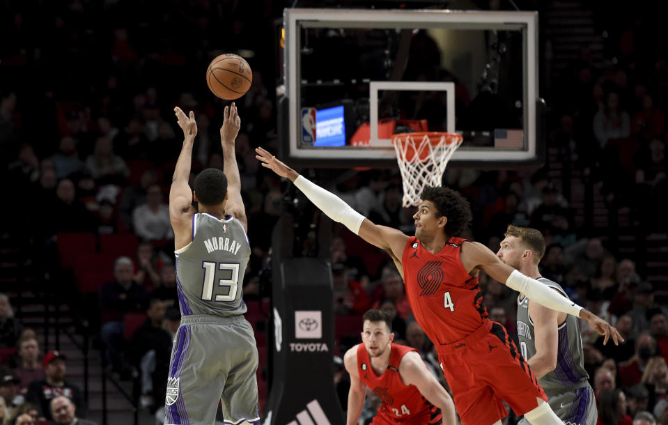 Sacramento Kings forward Keegan Murray, left, hits a shot over Portland Trail Blazers guard Matisse Thybulle, right, during the second half of an NBA basketball game in Portland, Ore., Wednesday, March 29, 2023. The Kings won 120-80. (AP Photo/Steve Dykes)