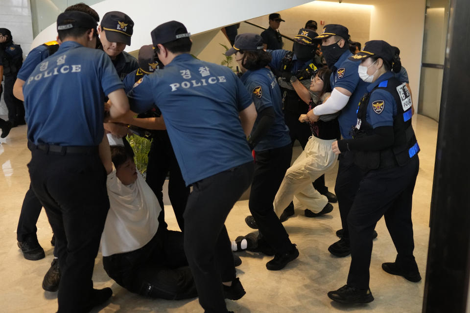 South Korean students are detained by police officers as they attempt to enter to Japanese Embassy to protest denouncing to release treated radioactive water into the sea from the damaged Fukushima nuclear power plant, at a building which houses Japanese Embassy, in Seoul, South Korea, Thursday, Aug. 24, 2023. The operator of the tsunami-wrecked Fukushima Daiichi nuclear power plant says it has begun releasing its first batch of treated radioactive water into the Pacific Ocean — a controversial step, but a milestone for Japan's battle with the growing radioactive water stockpile. (AP Photo/Lee Jin-man)